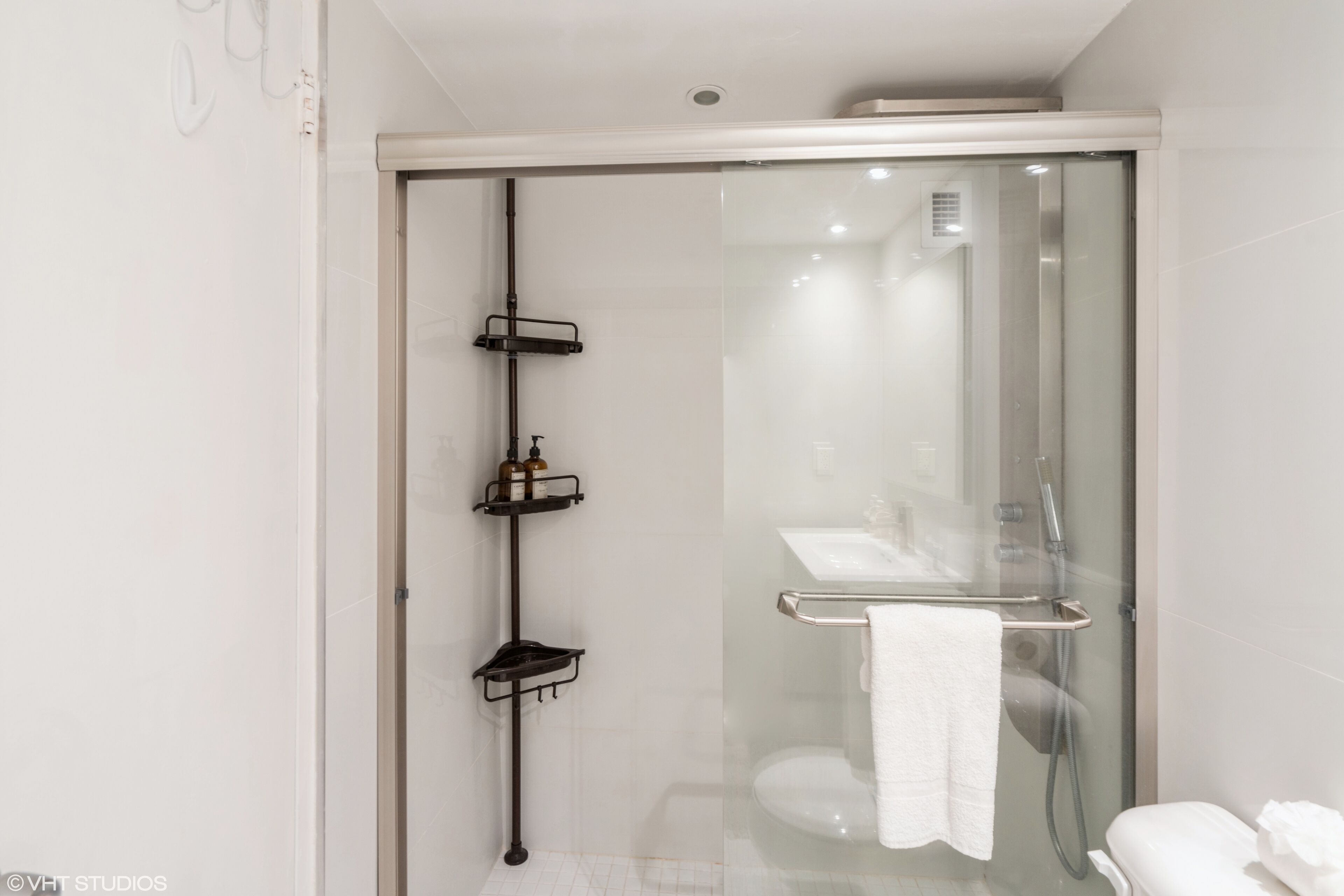 Une salle de bain moderne avec une douche à parois de verre, des toilettes à parois de verre et un lavabo blanc.