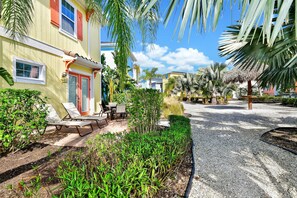 A tropical resort with a pool area, palm trees, and a well-maintained garden.
