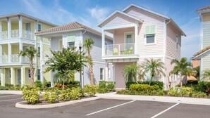 A row of two-story buildings with balconies, surrounded by well-maintained landscaping and a parking lot. - Delightful Cottage near Disney | Resort & Waterpark Access - 2956SR (Kissimmee)