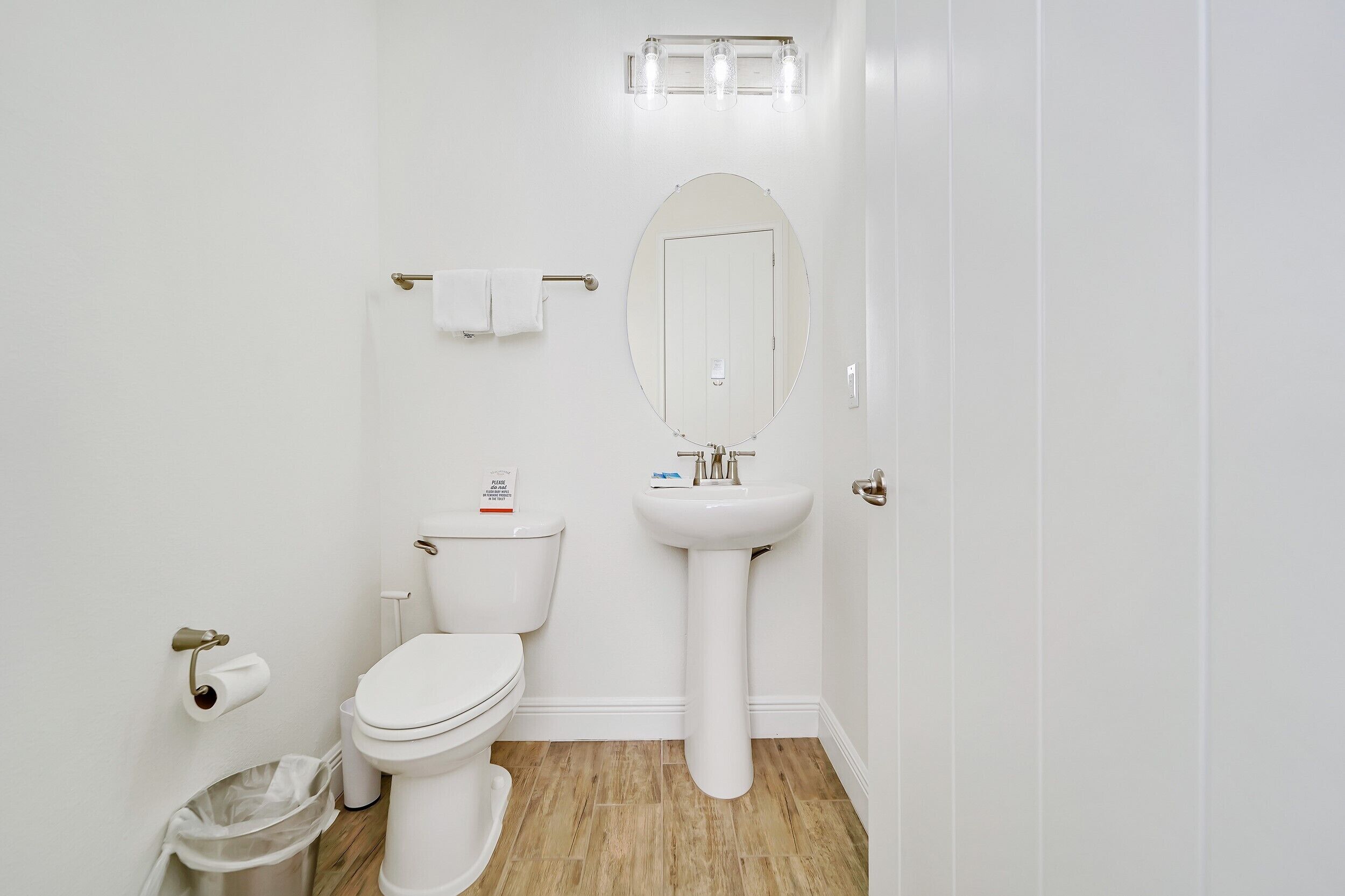 Un baño moderno con inodoro, lavamanos y espejo.
