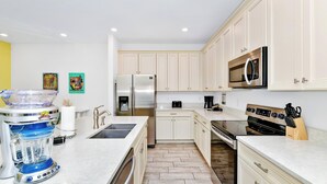 A modern kitchen with white cabinets, stainless steel appliances, and a granite countertop.