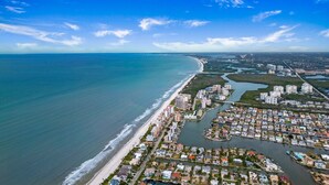 An aerial view of a coastal area with a beach, residential buildings, and a marina. - Vandy Villas — Walk to Vanderbilt Beach, Pool & Spa (Naples)