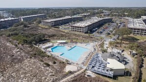 Un vaste complexe immobilier comprenant de nombreux espaces de stationnement et une piscine centrale.