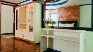 A room with a large wardrobe, a vanity with a mirror, and a wooden headboard. - Cozy vacation home for family in Uptown Cagayan de Oro City Close to everything (Cagayan de oro city)