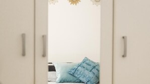 A bedroom with a bed, a blue pillow, and a wardrobe with a mirror. - Golden Teal apartment (BERGAMO)