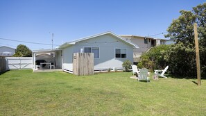 A single-story house with a covered patio, a fenced backyard, and outdoor seating. - Salt & Stone in Sunderland Bay (Sunderland Bay)