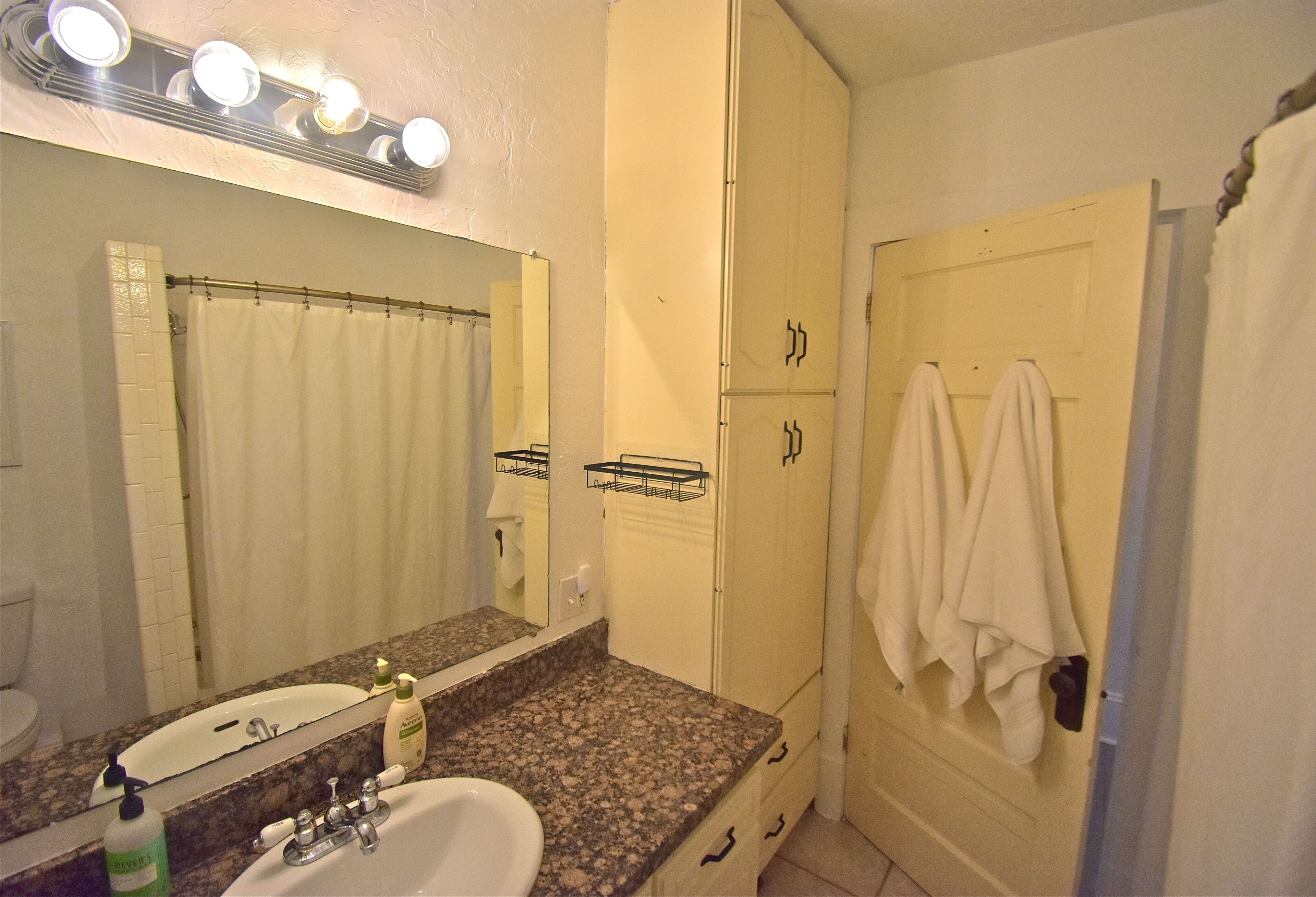 A bathroom with a sink, mirror, and towel rack.
