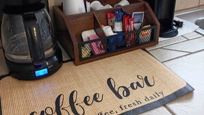 A kitchen counter with a coffee maker, a coffee station, and a sign that reads 'coffee bar brewed coffee fresh daily.' - Labor Day is open! SURFS UP! Family friendly. Finance with Affirm! (Dauphin Island)