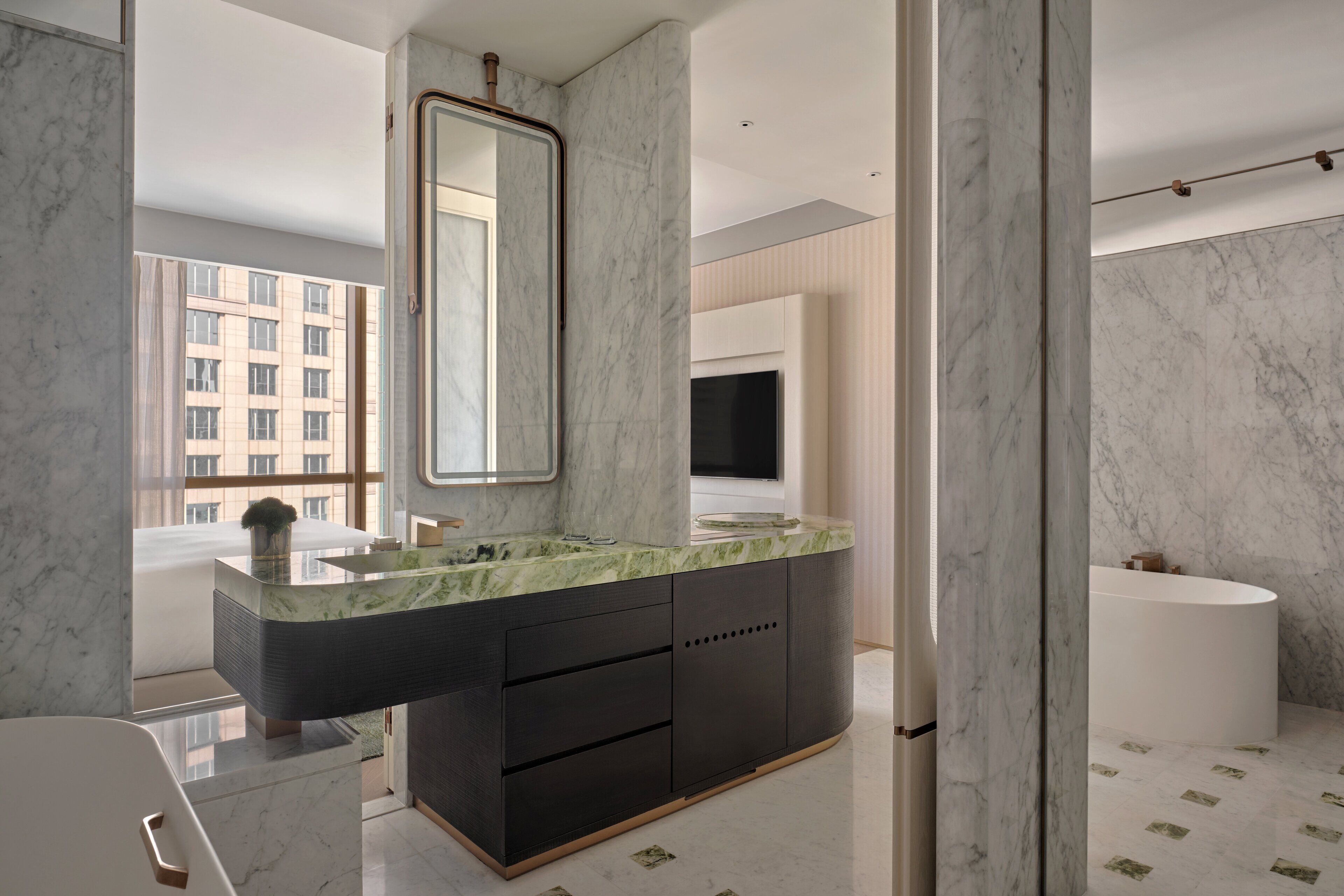 A modern bathroom with a marble vanity, a large mirror, and a bathtub.