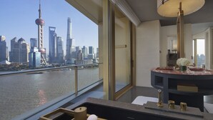 A modern bathroom with a large window overlooking a city skyline, including a distinctive tower. - Regent Shanghai On The Bund (Shanghai)