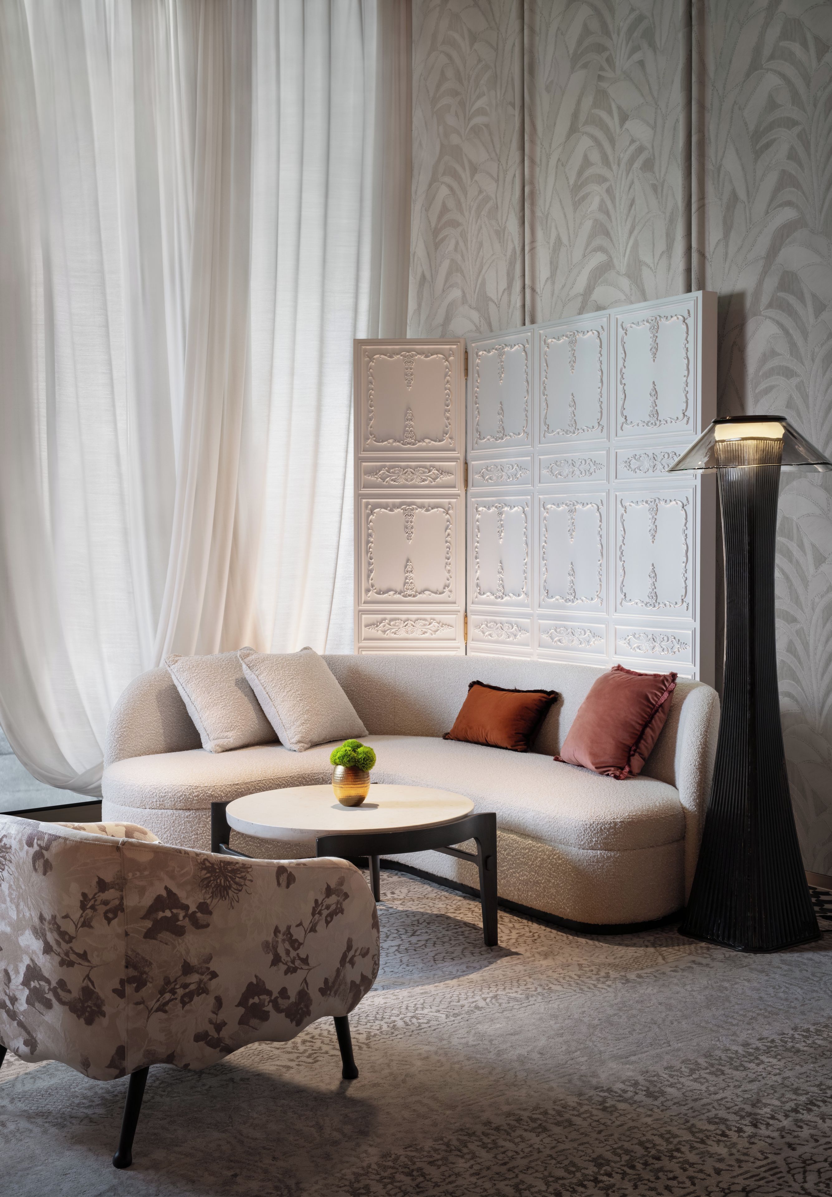 Ein modernes Wohnzimmer mit einer Couch, einem Couchtisch, einer Stehlampe und einer Zierverkleidung.
