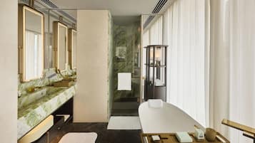 A modern bathroom with a marble vanity, a large mirror, a bathtub, and a glass shower enclosure.