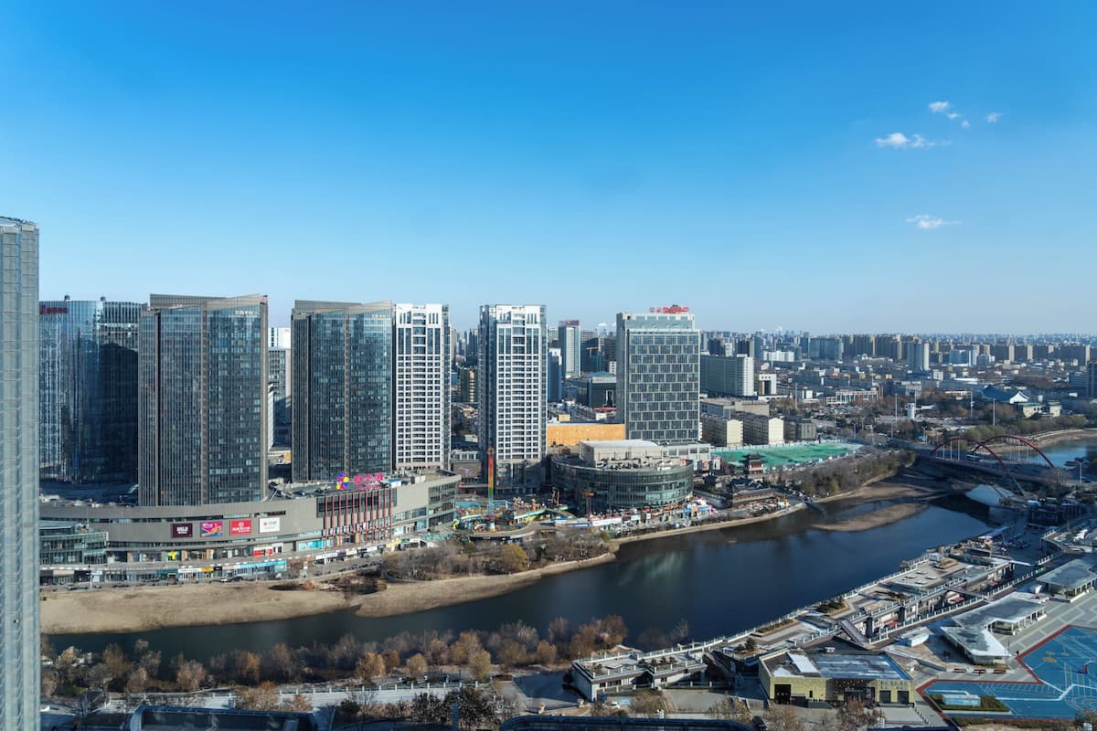 A cityscape with high-rise buildings, a river, and a bridge.