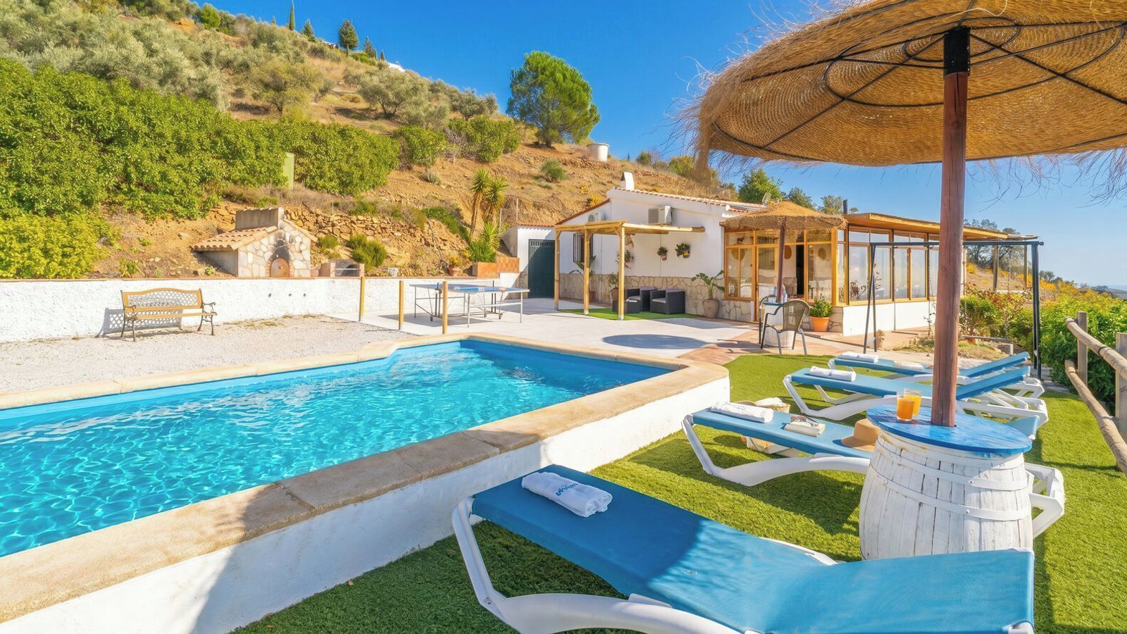 A pool with lounge chairs and a pergola.