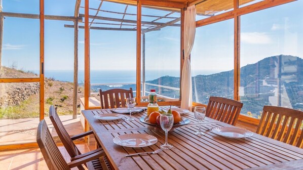 Enjoy a meal with a view from this dining table for two, overlooking the stunning coastal landscape.