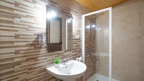 Een badkamer met een modern design, met een wastafel, spiegel en douche.