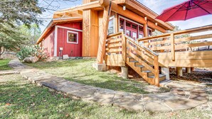 A wooden cabin with a red door, a wooden staircase, and a stone pathway. - Lake Whitney Cabin w/ Hot Tub & Fire Pit! (Morgan)