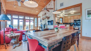 A spacious living area with a large wooden dining table, red chairs, and a ceiling fan. - Lake Whitney Cabin w/ Hot Tub & Fire Pit! (Morgan)