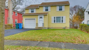 A two-story residential house with a garage, a front yard, and a tree. - Convenient, Pet-Friendly Rochester Vacation Rental (Rochester)