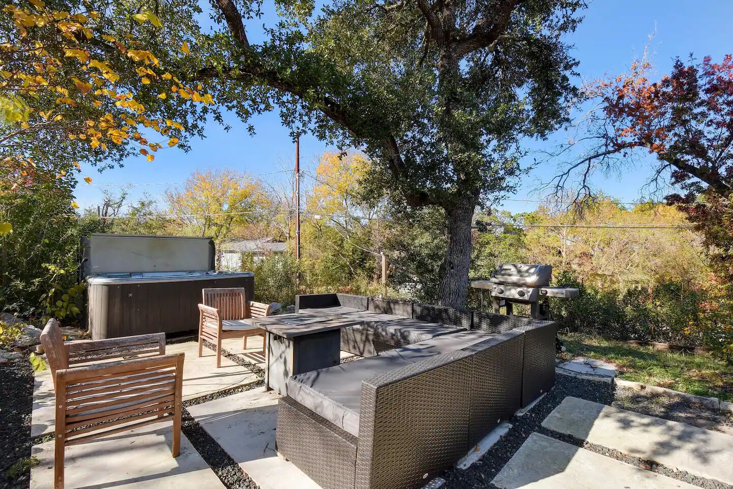 Eine Außenpatio mit Grill, Sitzgelegenheiten und einem Whirlpool.