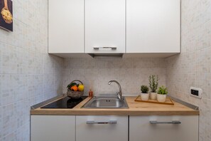 Een koelkast, een oven, een kookplaat, een koffiezetapparaat/waterkoker
