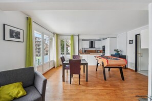 Relax in this spacious living area with a dining table, foosball table, and comfortable sofa.