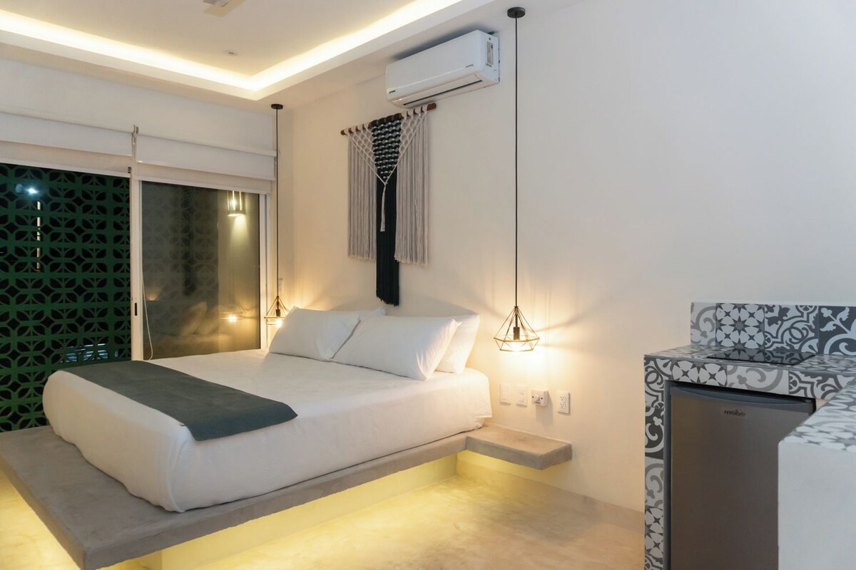 A modern bedroom with a bed, bedside table, air conditioning unit, and a patterned cabinet.