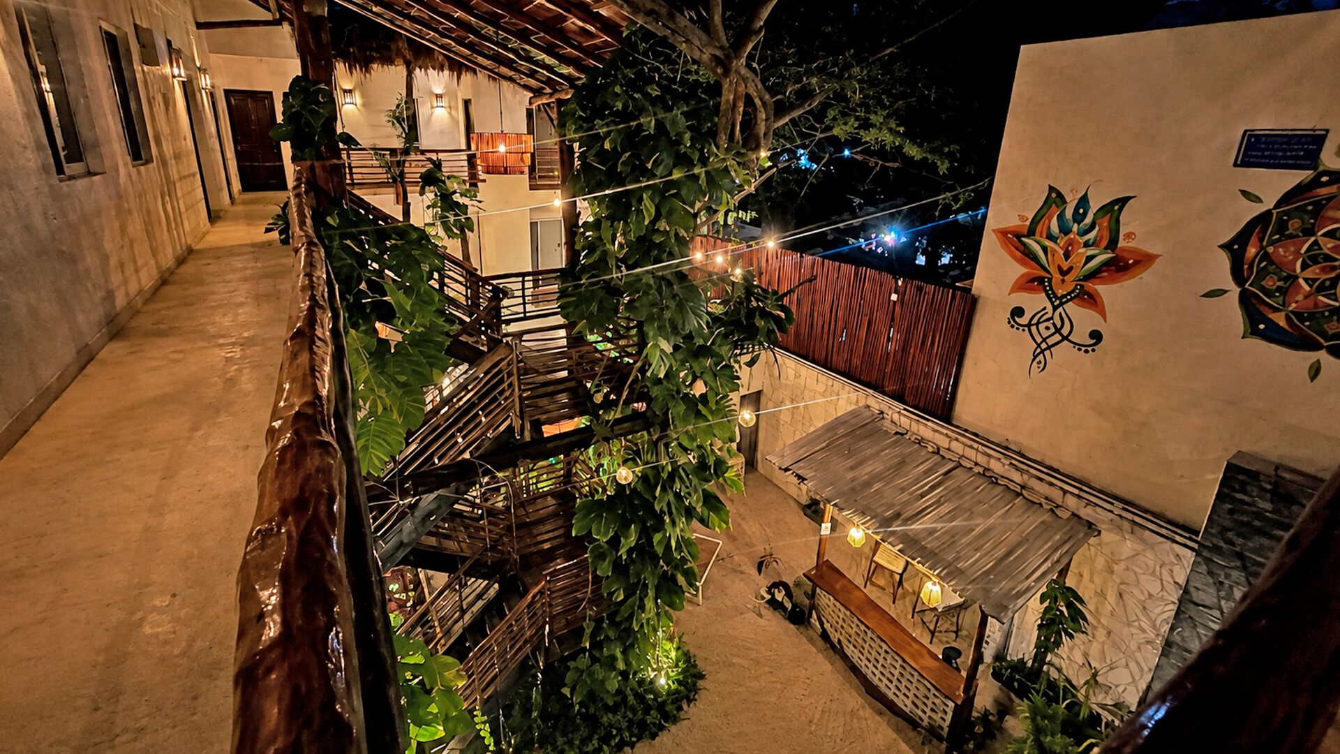 A courtyard with a staircase, plants, and a small outdoor seating area.