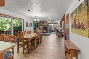 A dining area with wooden furniture, a fireplace, and a view of the outdoors.