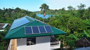 Een huis met een groen dak en zonnepanelen.