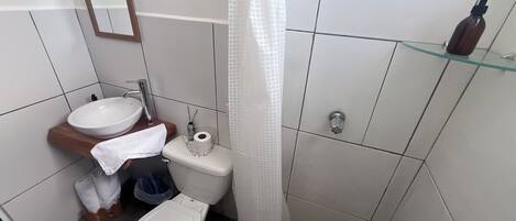 A bathroom with a white sink, toilet, and shower curtain.