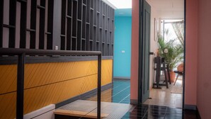A hallway with a staircase leading to a room with a view of the outside. - Lolas Hostal (San José)