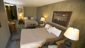 A hotel room with a large bed, two bedside tables with lamps, a chair, a desk, and a carpeted floor. - Iron Blosam Lodge at Snowbird with all the amenities you want. (Sandy)