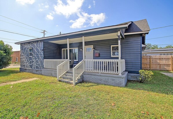 A single-story house with a front porch, a small front yard, and a mailbox.