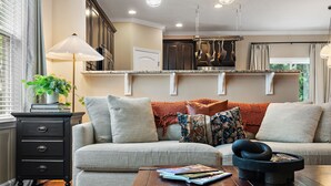 A living room with a sofa, a coffee table, a side table, and a lamp. - Elegant Home with Large Yard (Nashville)