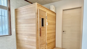 Una habitación con un armario de madera, una puerta y un ventanal con vistas a árboles.