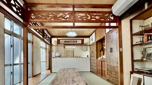 Una habitación tradicional al estilo japonés, con suelo de tatami, mostrador de recepción y puertas correderas de madera.