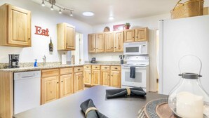 A modern kitchen with wooden cabinets, a built-in oven, microwave, and dishwasher. - Clean and comfortable with astounding views of Pikes Peak.  (Colorado Springs)