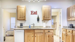 A kitchen with wooden cabinets, a granite countertop, a dishwasher, and a sign that says "Eat". - Clean and comfortable with astounding views of Pikes Peak.  (Colorado Springs)