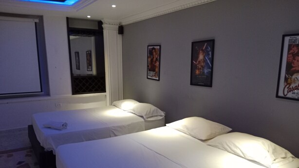 Ein Hotelzimmer mit zwei Einzelbetten, einem großen Spiegel und einem Bild an der Wand.