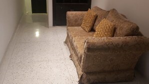 Ein Wohnzimmer mit einem gemusterten Sofa und zwei Zierkissen.