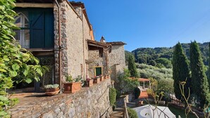 A stone building with a balcony overlooking a vineyard and rolling hills. - Beautiful  villa with WIFI, private pool, TV, terrace and panoramic view, close to Lucca (Chiatri)