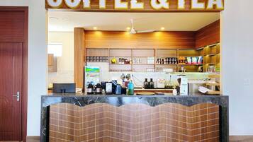 Un café-salon de thé doté d’un comptoir en bois, d’étagères remplies de divers articles et d’un décor intérieur moderne.