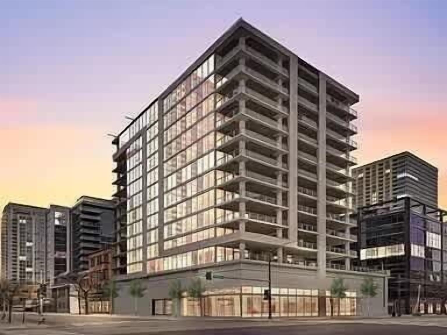 Een meerlaags gebouw met een modern architectonisch ontwerp, met een opvallende hoekstructuur en een reeks balkons.