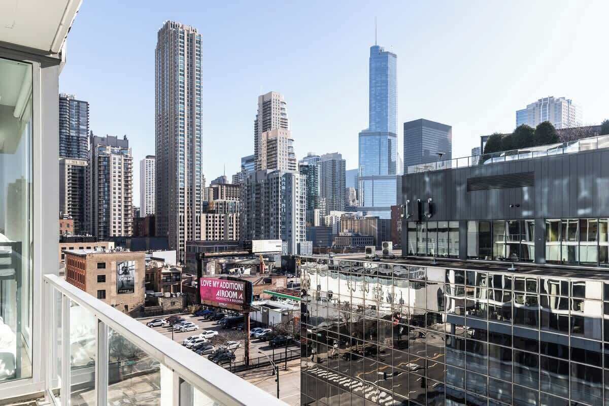 A high-rise building with a large glass facade, surrounded by other tall buildings in a cityscape.