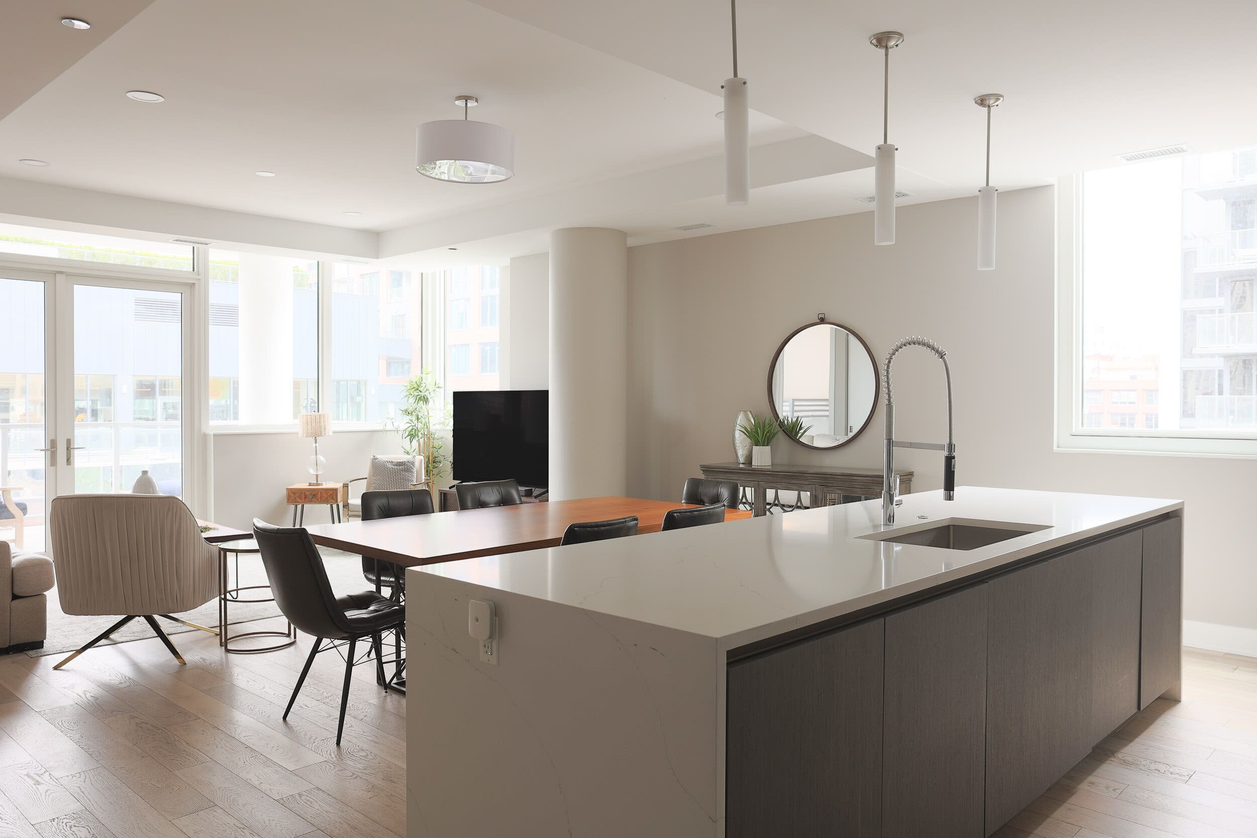 Een moderne keuken met een centraal eiland, een eethoek en een groot raam met uitzicht op de stad.