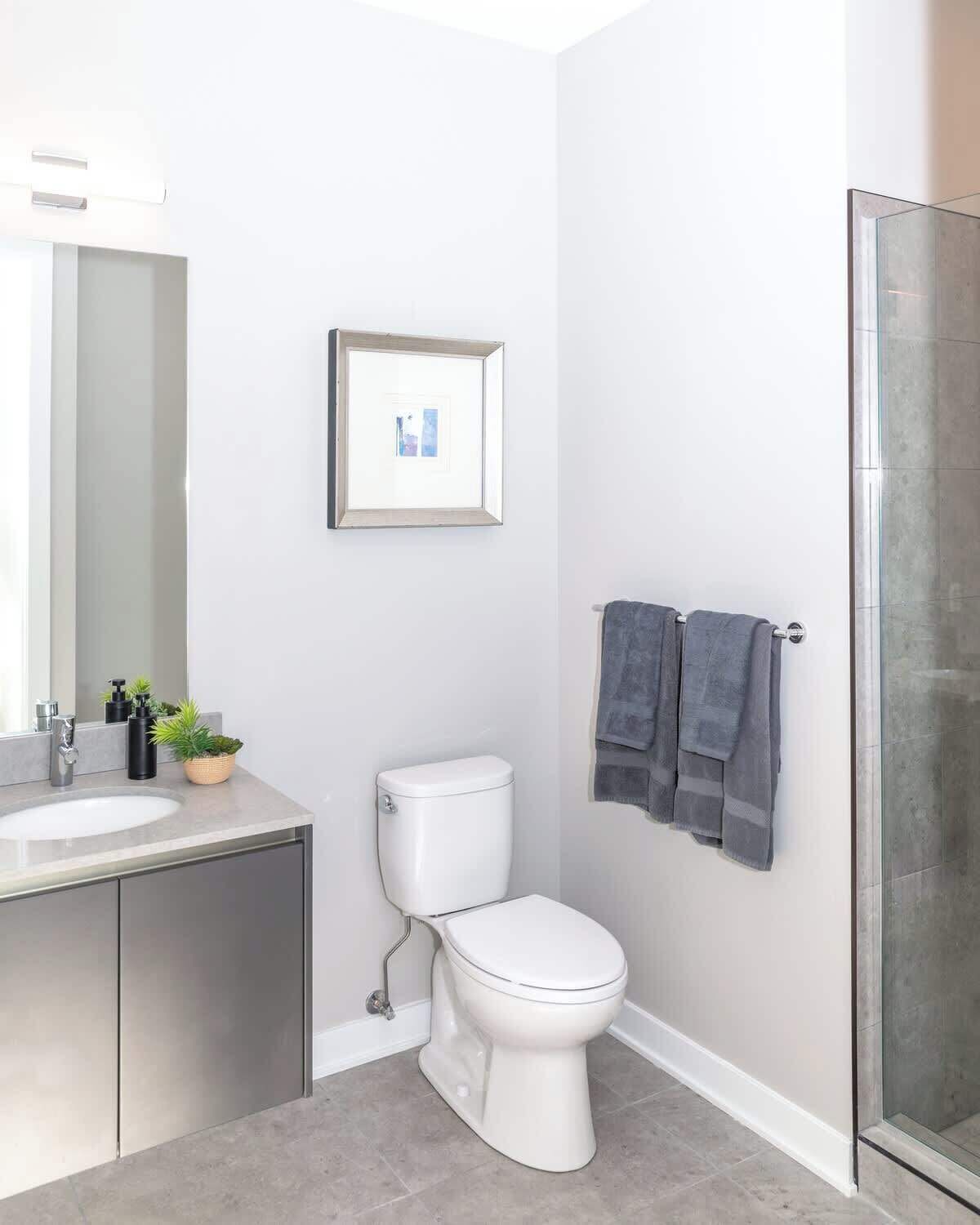 Ein modernes Badezimmer mit Toilette, Waschbecken und Dusche.