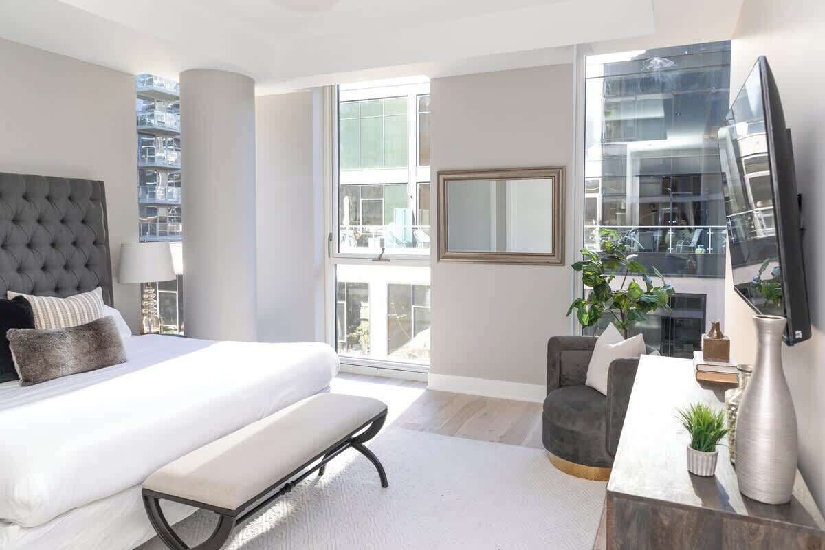 Een moderne slaapkamer met een groot bed, een bureau en een televisie.