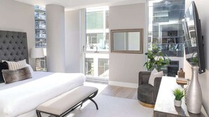 Une chambre moderne avec un grand lit, un bureau et une télévision.