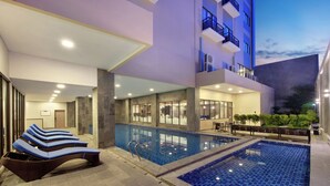A hotel pool area with lounge chairs and a separate smaller pool. - Aston Palu Hotel & Conference Center (Palu)